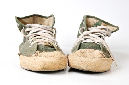 old used green sneakers on white backgroundの写真素材