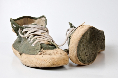 old used green sneakers on white backgroundの写真素材