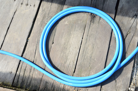 plastic hose isolated on the wooden floorの写真素材