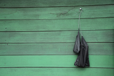 black plastic bags on the wooden wallの写真素材