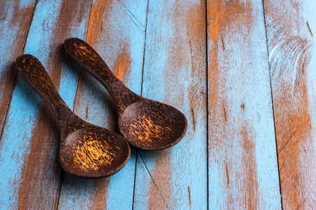 two wooden spoon on the old blue and brown tableの写真素材