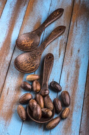 nutmeg on the wooden spoon at blue wooden tableの写真素材