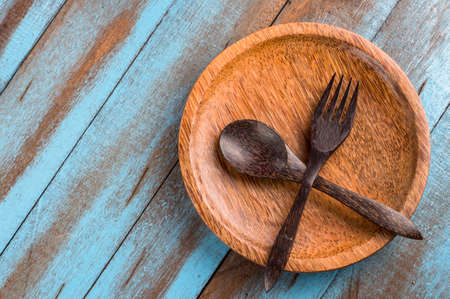 brown wooden spoon and fork on the wooden plateの写真素材