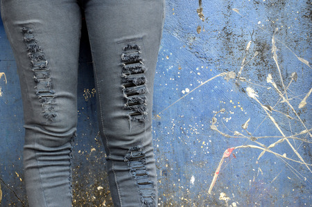 black faded jeans on concrete wallの写真素材