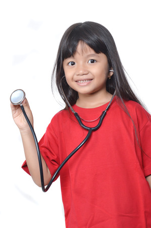 asian little girl dressed in red with a stethoscopeの写真素材