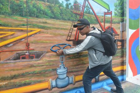 TARAKAN, INDONESIA - 4th August  2017 : the young man pose on the three-dimensional mural painting on the cement wallのeditorial素材