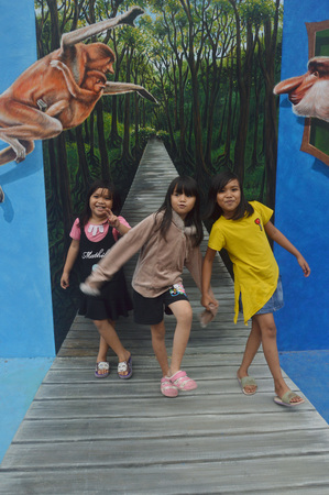 TARAKAN, INDONESIA - 5th August  2017 : the little girls pose on the three-dimensional mural painting on the cement wallのeditorial素材