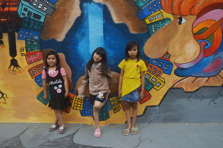 TARAKAN, INDONESIA - 5th August  2017 : the little girls pose on the three-dimensional mural painting on the cement wallのeditorial素材