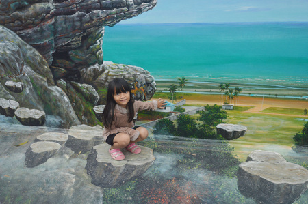 TARAKAN, INDONESIA - 5th August  2017 : the little girls pose on the three-dimensional mural painting on the cement wallのeditorial素材