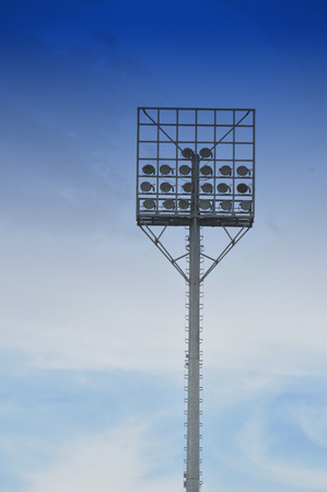 stadium light poles with white clouds and blue sky backgroundsの写真素材