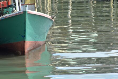 Wooden fishing boats are anchored at wooden docks around the settlementの写真素材
