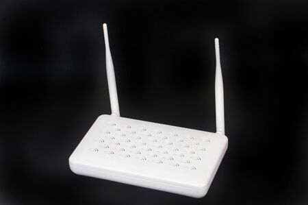white internet modem with two antennas on a black screenの写真素材