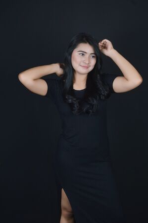 portrait of Beatiful Asian girl dressed in black photo shoot in a black background photo studioの写真素材