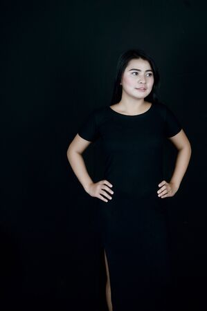 portrait of Beatiful Asian girl dressed in black photo shoot in a black background photo studioの写真素材