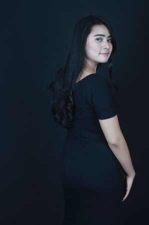 portrait of Beatiful Asian girl dressed in black photo shoot in a black background photo studioの写真素材