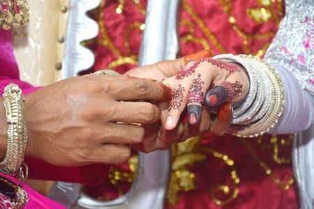 the Indonesian bridegroom attach the ring to the bride's fingerの写真素材
