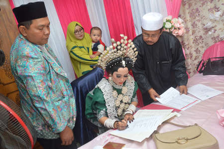 TARAKAN - INDONESIA, 16 MARCH 2019 : The bride signs the document from the religious departmentのeditorial素材