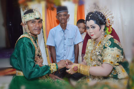 TARAKAN - INDONESIA, 5 NOVEMBER 2017 : the Indonesian bride attaches the ring to the groom's fingersのeditorial素材