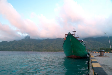 Experience the serenity of a tropical coast with this vibrant fishing boat waiting for its next adventure, evoking peace and wanderlust.の写真素材