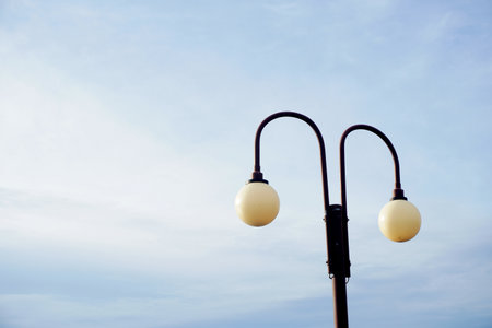 Serene dual lamppost stands against a softly hued sky, offering a clean, modern aesthetic perfect for conveying tranquility and urban design elements. Ideal for lifestyle and architectural concepts.の写真素材