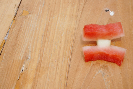Vibrant watermelon pieces artfully arranged on a textured wooden surface evoke summer freshness and healthy eating. Perfect for food blogs and lifestyle content.の写真素材