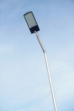 A contemporary LED street lamp stands tall on a metal pole, its bright illumination ready to light...