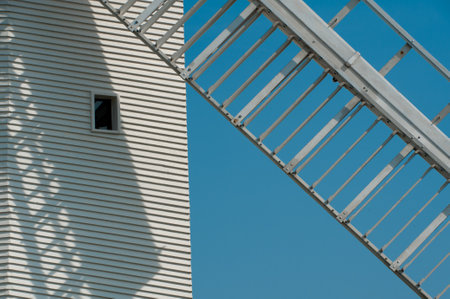 A windmill sail blade casts a shadow across the lined structure in contrasting black and white.の写真素材