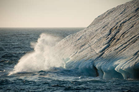 Sea spray is formed as sea water crashes against a drifting iceberg in Arctic waters.Nature.