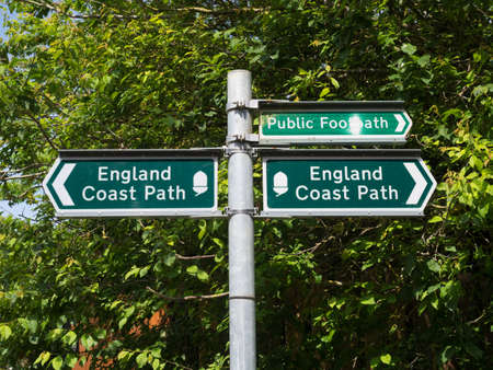 A signpost indicates the England Coast Path with arrows to left and right.Signpost.Footpathの写真素材