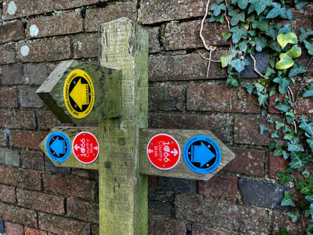 A footpath sign post indicates routes on 1066 Country Walk.East Sussex County Council footpath and bridleway signsのeditorial素材