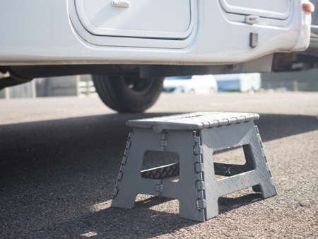 Close view of a portable collapsible step has been placed on ground outside a motorhome recreational vehicle to aid entry to the habitation doorの写真素材