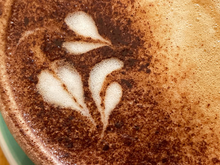 Close up view from above of the decorations and swirls made in a cappuccino coffee.Chocolate sprinkles visibleの写真素材
