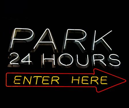 neon car park sign isolated on blackの写真素材