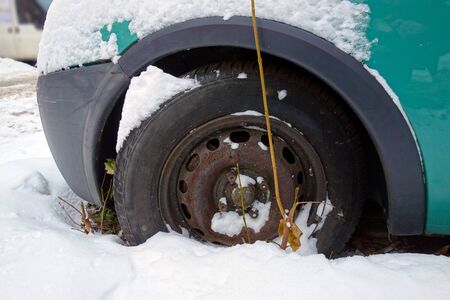 Wheel of an old car in the snowの写真素材