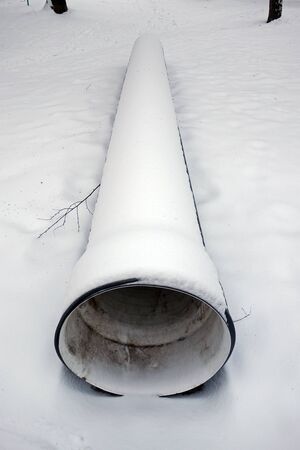 Sewerage pipeline in a snowy parkの写真素材