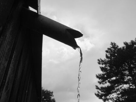 Flowing water stream from the rain drain pipeの写真素材