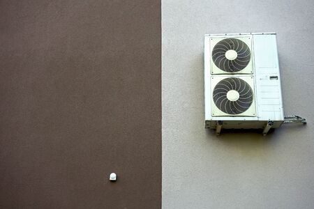 Air conditioner attached to the insulated wall of the buildingの写真素材