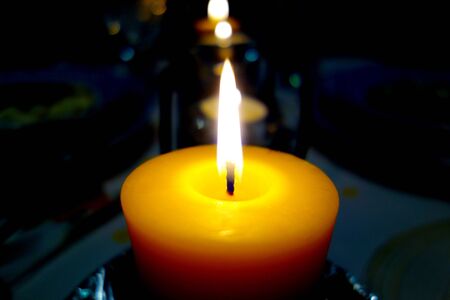 Burning candle of beeswax in a dark areaの写真素材
