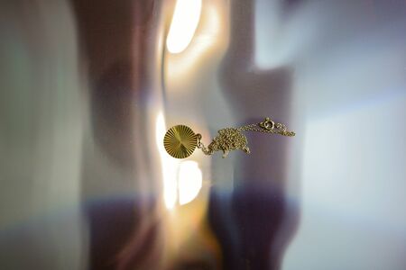 Gold chain on mirrored plastic foil