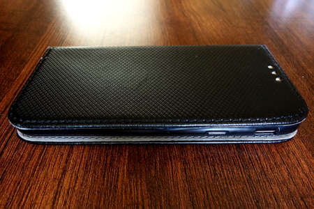 Mobile phone in a case on a wooden table