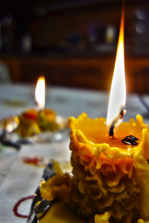 Burning beeswax candle on a Christmas tableの写真素材