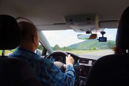 Male driver with woman in car traveling on vacation