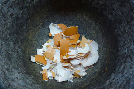 Crushed eggshells in a mortar made of massive natural graniteの写真素材