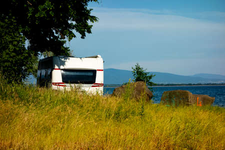 A caravan is built on the lake shore in a recreation center in the summer season