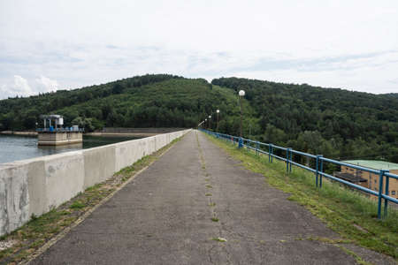 Walkway along the dam of DomaÅ¡a Slovakia. To the right is a small hydroelectric power plant and to the left is a technological device to regulate the flow of waterの写真素材