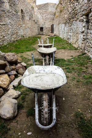 Wheelbarrow full of mortars, renovation work on the old castle Jasenov Slovakiaの写真素材