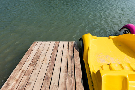 A plastic boat on a pier in a recreation center on a lakeの写真素材