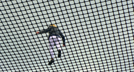 A young woman walks along the safety net at the top of the observation towerの写真素材