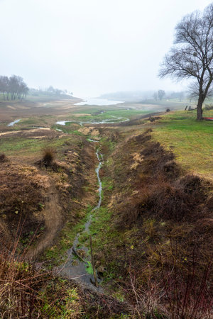Lack of water in Lake DomaÅ¡a Slovakia in winter with an exposed bottomの写真素材