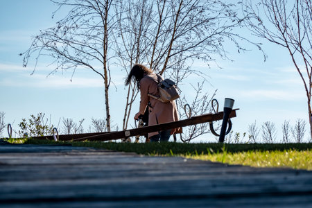 A mother and child play on a swing on a playground in nature